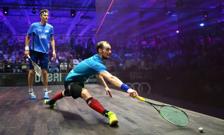 Gregory Gaultier (front) plays a backhand to Cameron Pilley in the men's final match of the Dubai PSA World Series finals squash tournament, on May 28, 2016
