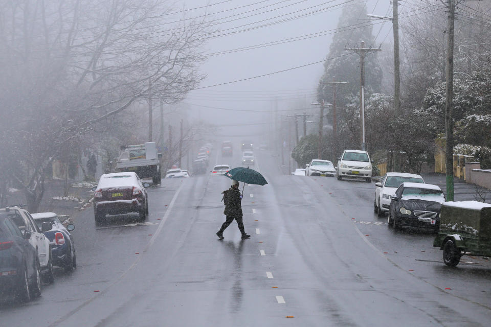A person crosses the street during snowfall in Katoomba, NSW. Source: AAP