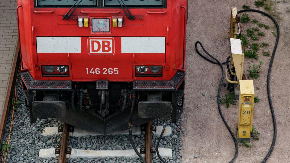 Eine Lokomotive der Deutschen Bahn steht vor dem Kieler Hauptbahnhof auf den Gleisen und ist an Versorgungsleitungen angeschlossen.