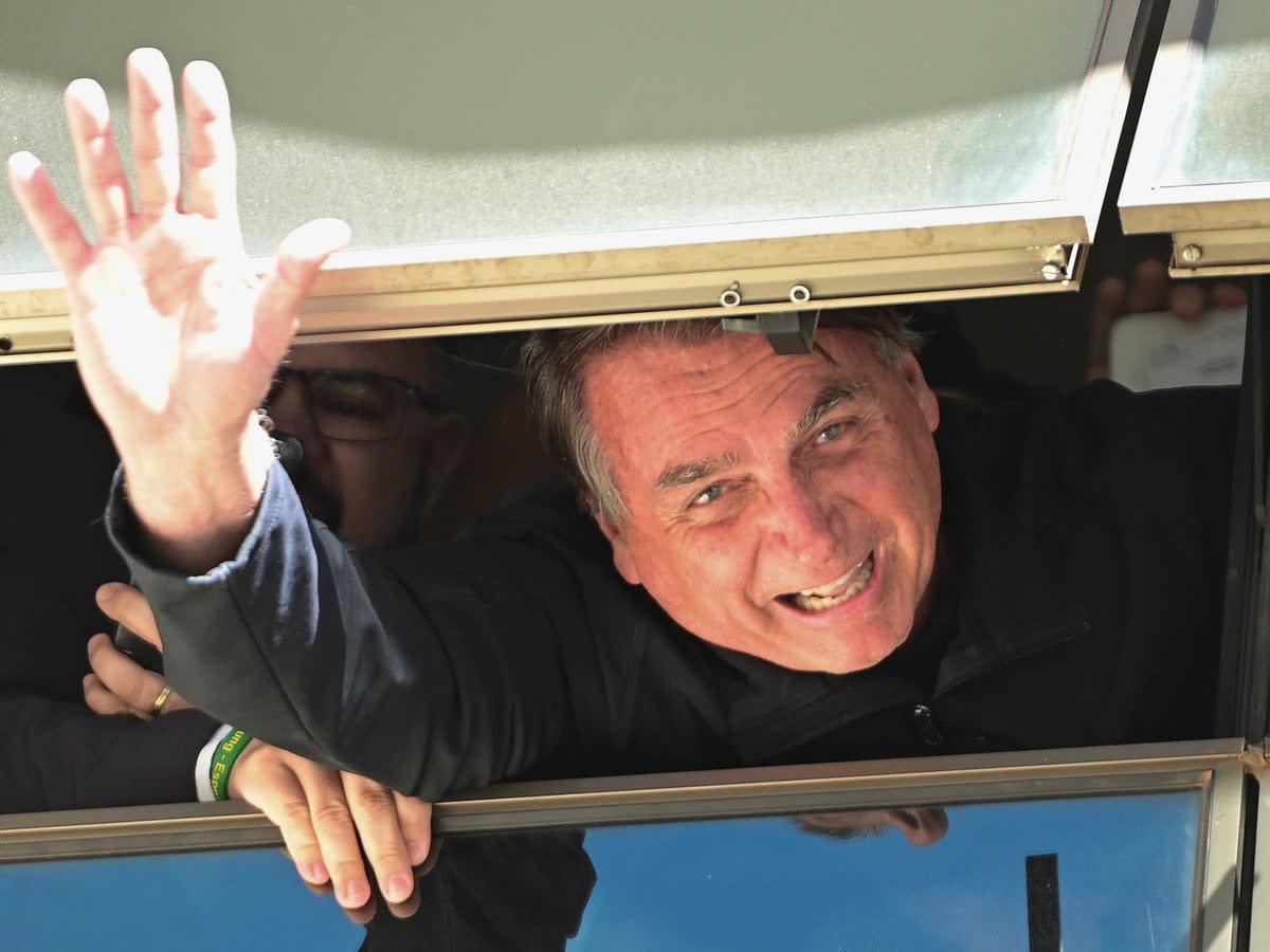 Jair Bolsonaro waves to supporters at Brasilia International Airport (Ton Molina /Reuters)