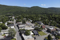 Surrounded by trees and mountains, Ellenville, N.Y., is seen Wednesday, June 16, 2021. Less than 100 miles north of New York City, Ulster County is popular destination for weekenders headed to Woodstock or the Catskill Mountains. Though pretty, there are pockets of poverty. The county is working with the Center for Guaranteed Income Research at the University of Pennsylvania on a pilot program funded by private donations. One hundred households making less than $46,900 a year in May began receiving a $500 payment each month for a year. Recipients of the money can spend it as they wish, but will be asked to participate in periodic surveys about their physical health, mental health and employment status. (AP Photo/Seth Wenig)