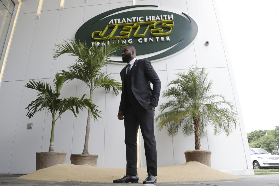 Former New York Jets cornerback Darrelle Revis stands in front of a makeshift island at the main entrance to the team's training facility after a news conference officially announcing his retirement Tuesday, July 24, 2018, in Florham Park, N.J. Revis leaves behind an 11-season career that included four All-Pro selections and a Super Bowl win with the New England Patriots. (AP Photo/Julio Cortez)