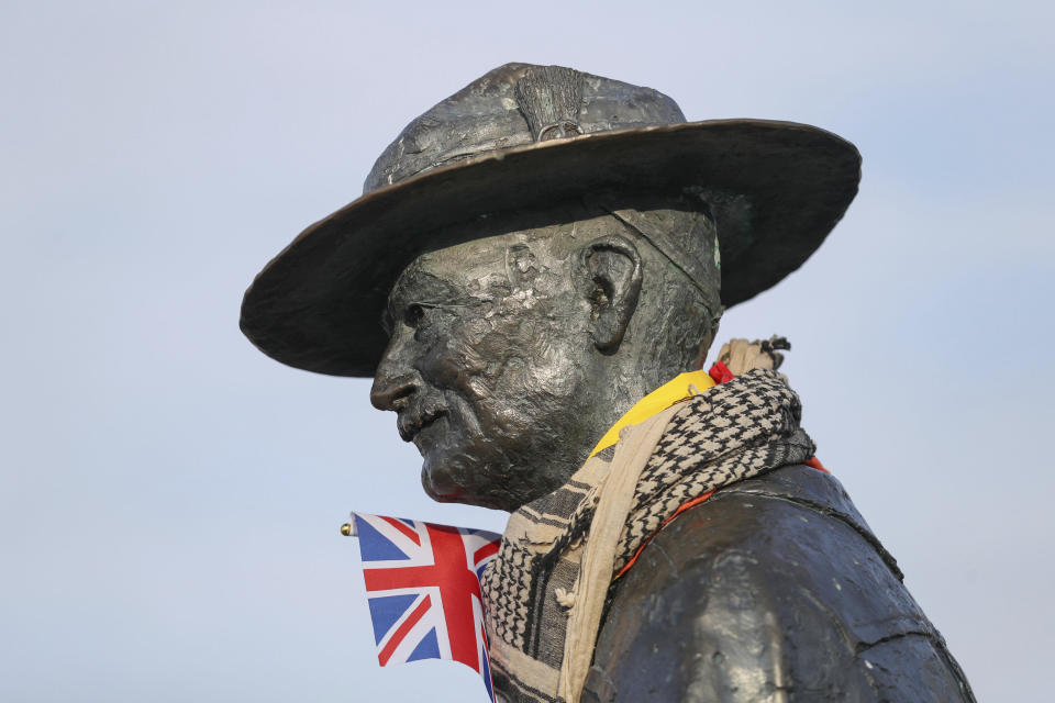 A scarf with the British flag hangs around the neck of a statue of Robert Baden-Powell on Poole Quay in Dorset, Britain, Friday June 12, 2020. Officials plan to remove a statue of the founder of the Scouts movement from the quayside in Poole, southern England, out of concern it may be a target for protests ignited by the death of George Floyd, who died after he was restrained by Minneapolis police on May 25. (Andrew Matthews/PA via AP)