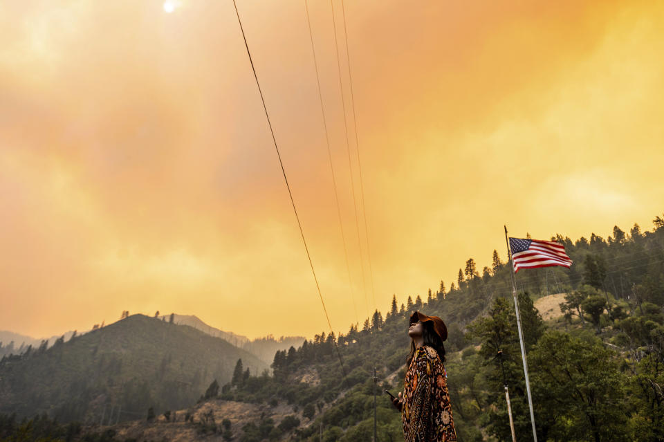 Jessica Bell watches as the Dixie Fire burns along Highway 70 in Plumas National Forest, Calif., on Friday, July 16, 2021. (AP Photo/Noah Berger)