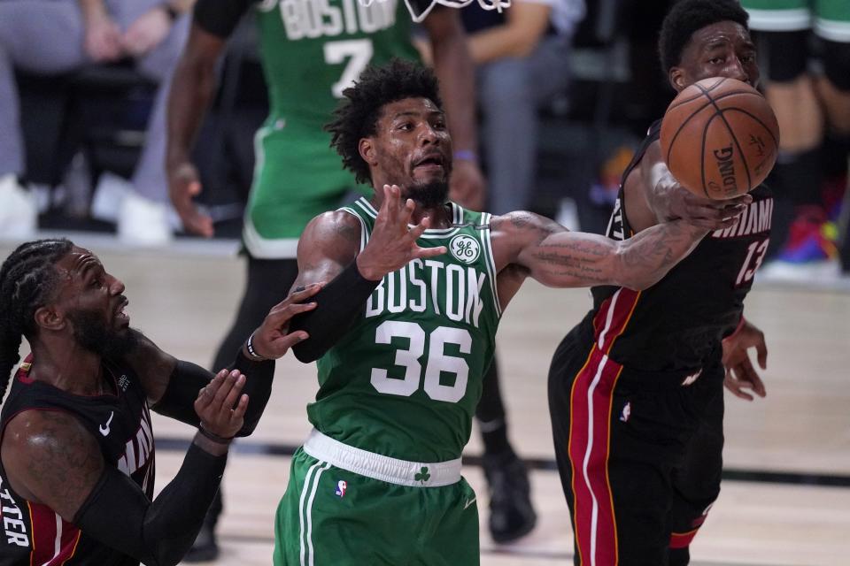 Boston Celtics guard Marcus Smart (36) competes for a rebound against Miami Heat's Jae Crowder, left, and Bam Adebayo, right, during the second half of an NBA conference final playoff basketball game, Saturday, Sept. 19, 2020, in Lake Buena Vista, Fla. (AP Photo/Mark J. Terrill)