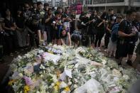 People pay their respects at the site where a man fell from a scaffolding at the Pacific Place complex while protesting against a proposed extradition bill, in Hong Kong