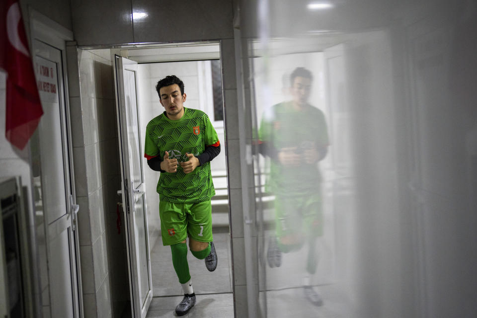 Amateur goalkeeper Mustafa Mert Olcer leaves the locker room before playing a recreational soccer "Astroturf" match in Istanbul, Turkey, Tuesday, March 5, 2024. More than a few times a week, the 18-year-old courier and passionate goalkeeper Mustafa Mert Olcer, gets a call from Rent-a-Goalkeeper to man a goalpost. (AP Photo/Francisco Seco)