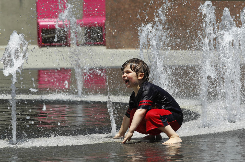 Thijs Talluto, 3, of Los Angeles, plays in a fountain at Grand Park in downtown Los Angeles Monday, May, 12, 2014. A warm weekend gave way to a sweltering work week in Southern California, with whipping winds of the sort already felt across the West bringing dry conditions and high fire danger. After a hot, windy Mother's Day with temperatures in the mid-80s, a high pressure system was expected to heighten the heat slightly Monday before pushing it to near triple digits in some spots midweek, mostly inland areas already badly parched by drought. High temperatures will extend up and down California, according to the National Weather Service.(AP Photo/Nick Ut )