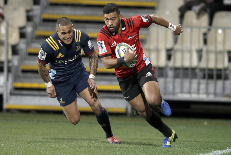 Crusaders Richie Mo'unga, right, runs in to score his teams second try as Highlanders Aaron Smith chases during the Super Rugby quarterfinal between the Crusaders and the Highlanders in Christchurch, New Zealand, Friday, June 21, 2019. (AP Photo/Mark Baker)