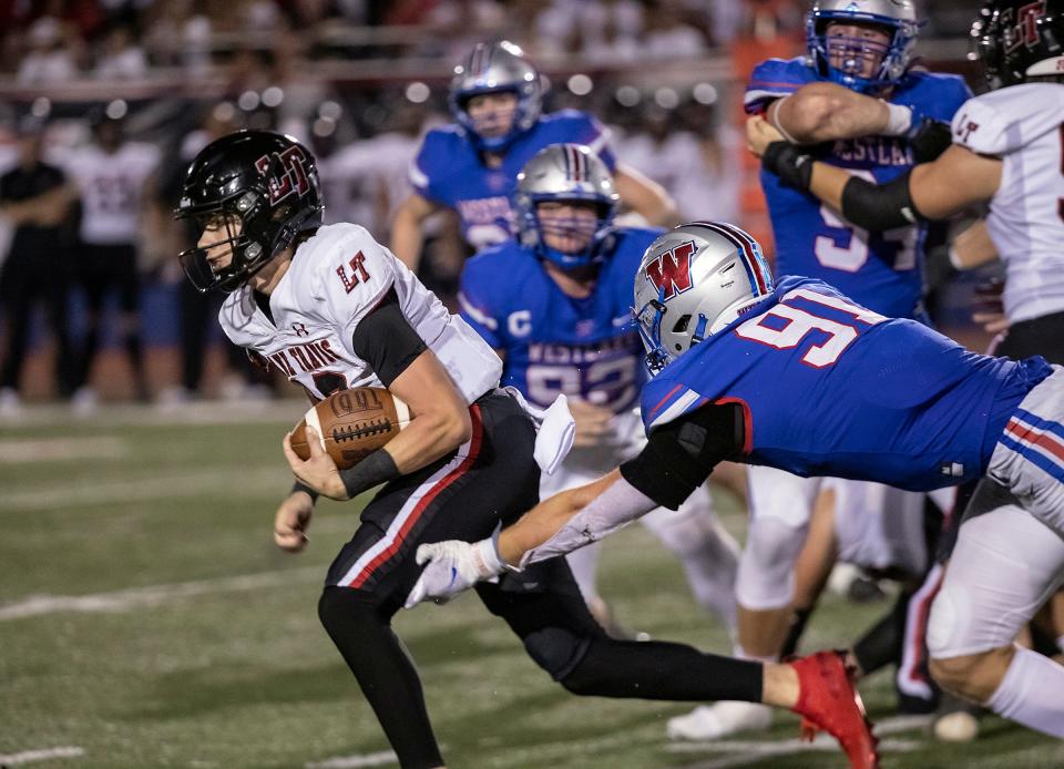 Lake Travis quarterback Kadyn Leon, left, tries to escape the grasp of Westlake defensive lineman Colton Vasek during last fall's 35-20 Chaparrals victory at Westlake High School. Like last year, the two power programs of Central Texas will face each other in September, not November.