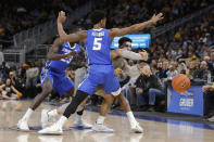 Marquette's Markus Howard passes out of a double-team by Creighton's Ty-Shon Alexander (5) and Damien Jefferson (23) during the first half of an NCAA college basketball game Tuesday, Feb. 18, 2020, in Milwaukee. (AP Photo/Aaron Gash)