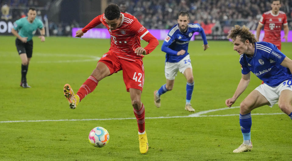 Bayern's Jamal Musiala, left, passes the ball with the hoe to teammate Gnabry (not in the picture, scoring the opening goal during the German Bundesliga soccer match between FC Schalke 04 and Bayern Munich in Gelsenkirchen, Germany, Saturday, Nov. 12, 2022. (AP Photo/Martin Meissner)