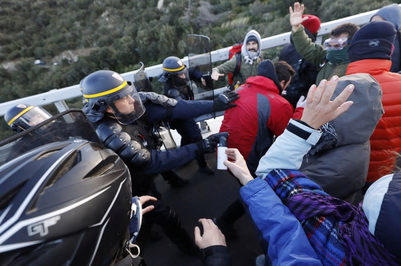 Members of Catalan protest group Democratic Tsunami clash with French police officers at the AP-7 highway