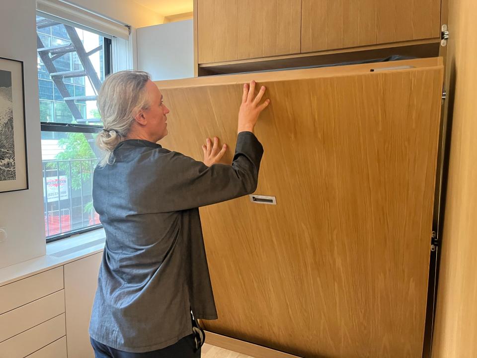 Robert Garneau pushes the Murphy bed back into the wall. 