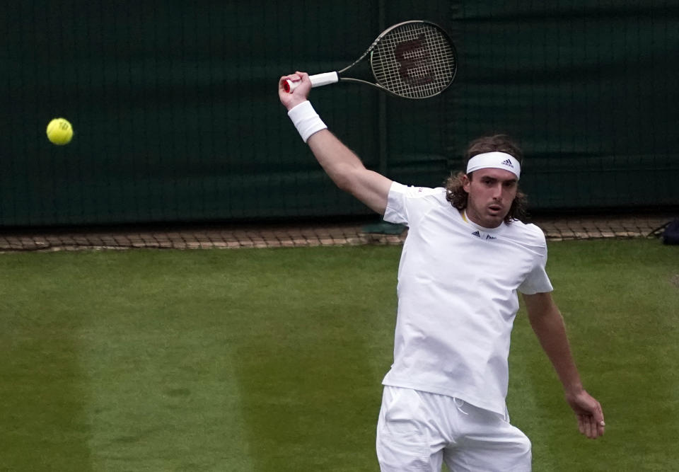 Greece's Stefanos Tsitsipas returns to Australia's Nick Kyrgios during their third round men's singles match on day six of the Wimbledon tennis championships in London, Saturday, July 2, 2022. (AP Photo/Alberto Pezzali)