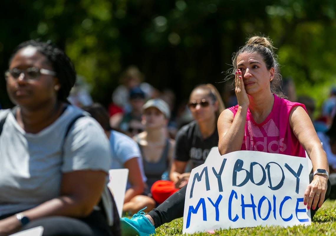 Maria Laura Alfonsin, from Aventura, wipes a tear as she listens to speakers at the Bans Off Our Bodies rally at Ives Estates Park in Miami, Florida on Saturday, May 14, 2022.