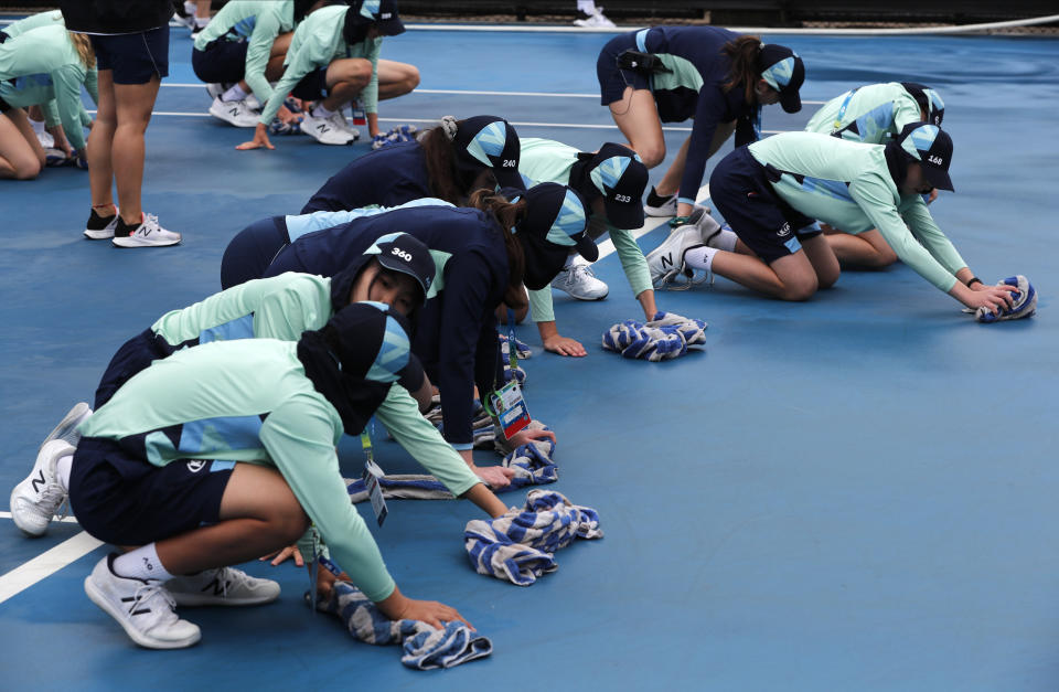 Ball kids dry off outside courts as play is delayed by rain at the Australian Open tennis championship in Melbourne, Australia, Thursday, Jan. 23, 2020. (AP Photo/Andy Wong)