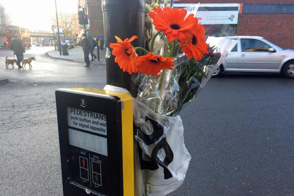 Flowers left close to the scene in Tulse Hill where a woman died. (PA)