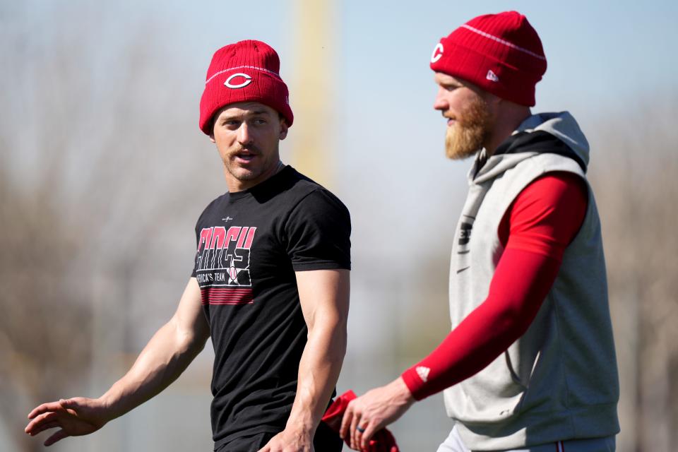 Cincinnati Reds outfielders T.J. Friedl, left, and Jake Fraley talk after long tosses during spring training workouts, Saturday, Feb. 17, 2024, at the team's spring training facility in Goodyear, Ariz.