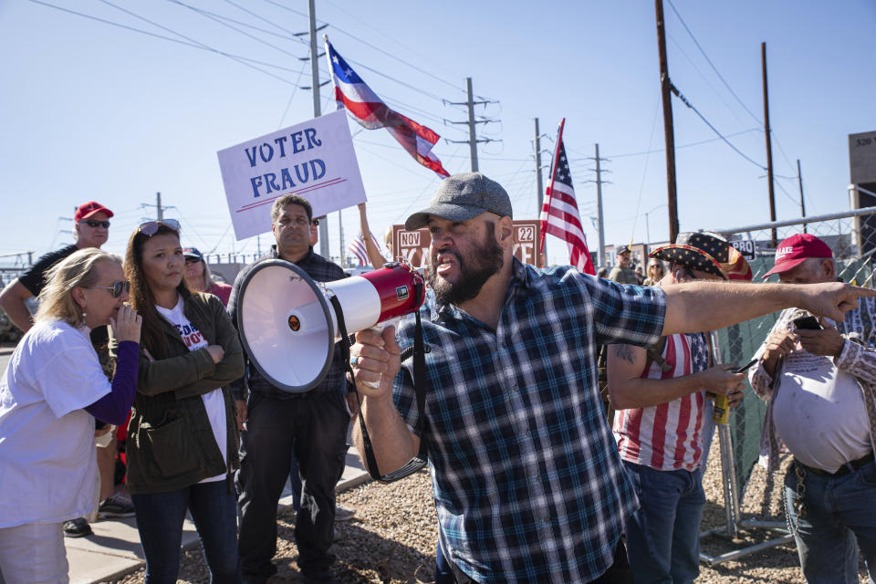 FILE - Republican supporters stand outside the Maricopa County Recorder's Office to protest what they allege is an unfair election in Phoenix, Nov. 12, 2022. According to a bipartisan report released Tuesday, Feb. 6, 2024, that calls for greater transparency and steps to make voting easier, a “tumultuous period of domestic unrest” combined with a complicated and highly decentralized election system has led to a loss of faith in election results among some in the U.S. (AP Photo/Alberto Mariani, File)