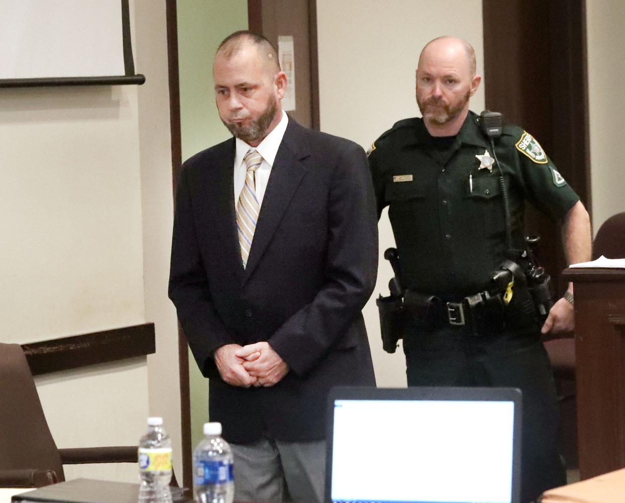 Damian DeRousha is escorted to the defense table by a Volusia County Sheriff's Office bailiff, Tuesday, May 17, 2022, before the start of his trial in the shooting death of Donald Geno in 2021.