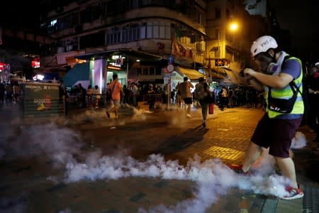People run away from tear gas fired by police to disperse anti-extradition bill protesters demonstration at Sham Shui Po