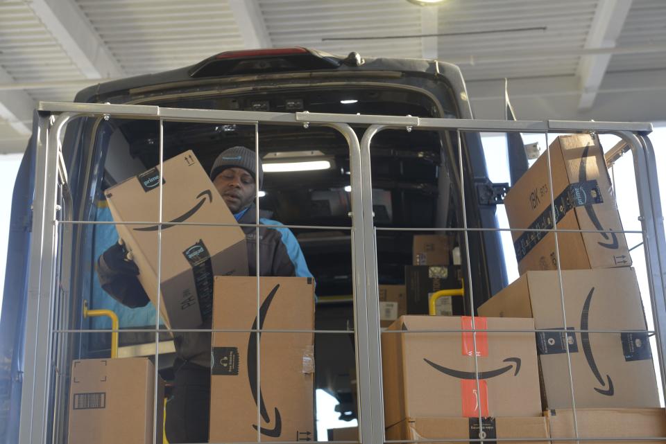 Delivery driver Fongoh LoknjinuAtanga loads packages into an Amazon delivery van Wednesday, Nov. 23, 2022, in St. Cloud.