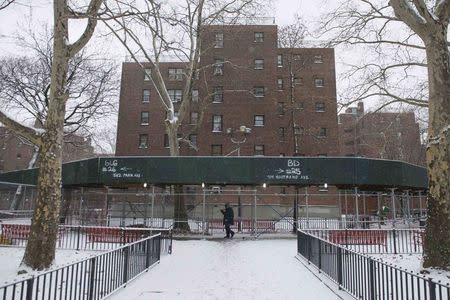 A man walks through the Marcy Houses public housing development in the Brooklyn borough of New York January 9, 2015. REUTERS/Stephanie Keith