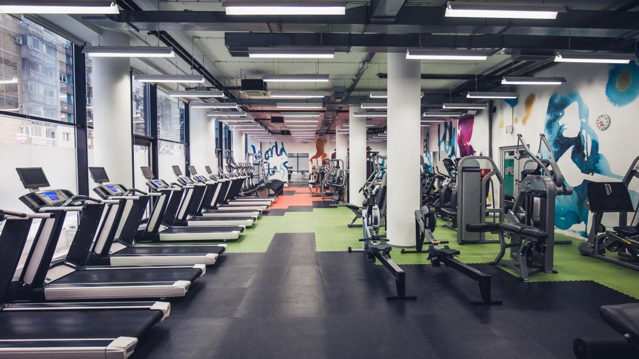 Large group of exercise machines in an empty gym.