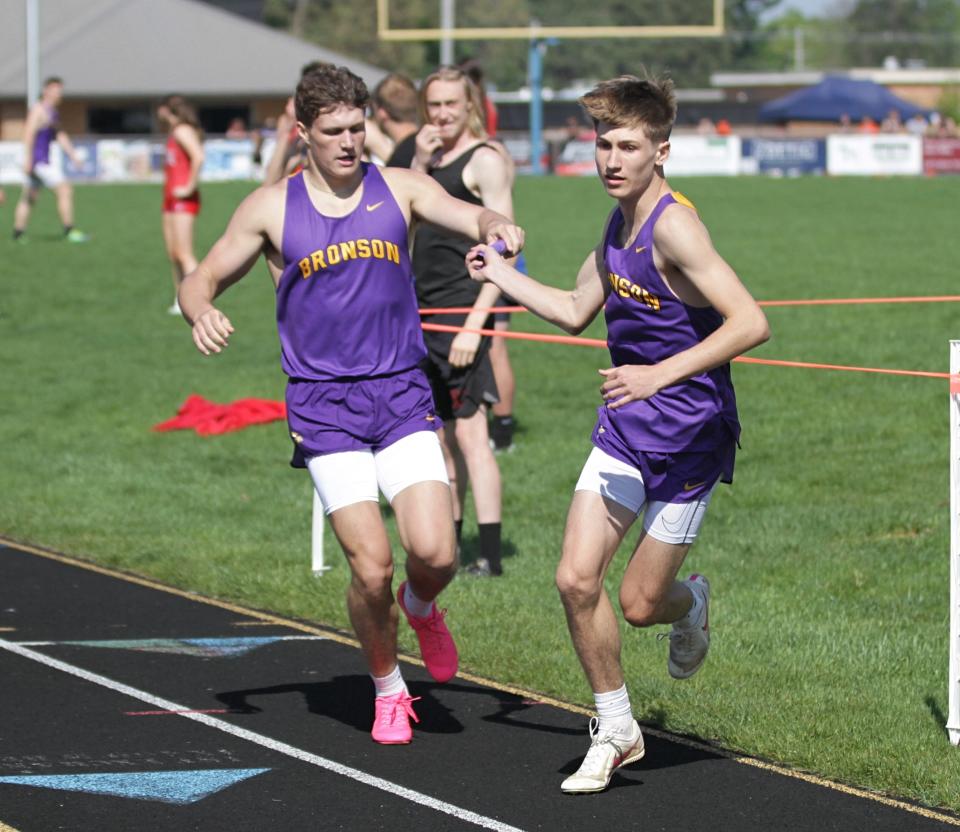 Boston Bucklin hands the baton off to Kam Brackett for Bronson in the two-mile relay, which they won.