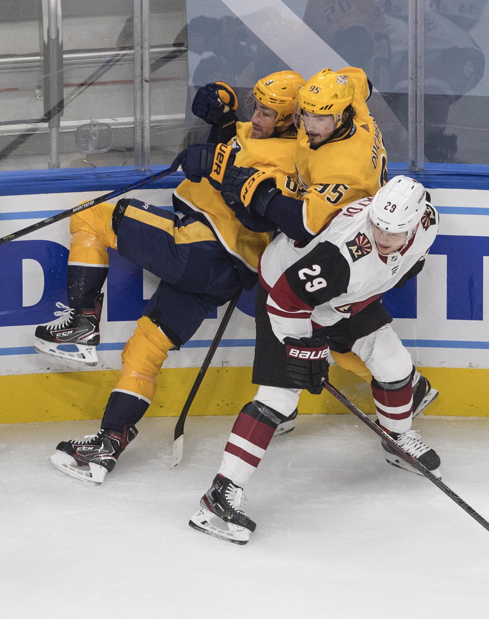 Nashville Predators' Filip Forsberg (9) and Matt Duchene (95) crash into Arizona Coyotes' Barrett Hayton (29) during first period NHL qualifying round game action in Edmonton, on Sunday, Aug. 2, 2020. (Jason Franson/The Canadian Press via AP)