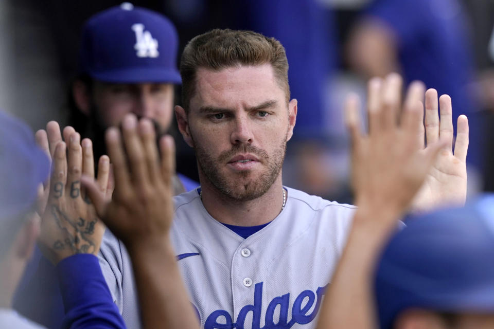 Los Angeles Dodgers' Freddie Freeman celebrates in the dugout after scoring on a double by Max Muncy during the fifth inning of a baseball game against the Chicago White Sox Thursday, June 9, 2022, in Chicago. (AP Photo/Charles Rex Arbogast)