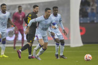 Cristiano Ronaldo, right, playing for a combined XI of Saudi Arabian teams Al Nassr and Al Hilal is challenged by PSG's Lionel Messi during a friendly soccer match, at the King Saud University Stadium, in Riyadh, Saudi Arabia, Thursday, Jan. 19, 2023. (AP Photo/Hussein Malla)