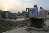 In this Nov. 28, 2018 photo, elderly Nepalese people watch the construction of Janakpur train station at Janakpur, from where a new rail line connects to Jay Nagar in the Indian state of Bihar. The competition between two Asian giants, India and China, for influence over tiny Nepal is yielding a bonanza in the form of the Himalayan mountain nation’s first modern railway, and possibly more to come. (AP Photo/Niranjan Shrestha)(Hold for Nepal-India train Story)