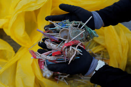 FILE PHOTO: A volunteer shows ear sticks and plastics after a garbage collection, ahead of World Environment Day on La Costilla Beach, on the coast of the Atlantic Ocean in Rota, Spain June 2, 2018. REUTERS/Jon Nazca/File Photo