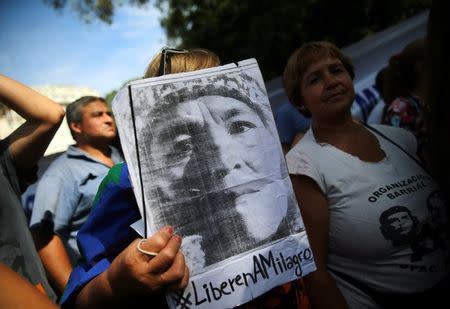 A woman holds a portrait of Milagro Sala, the leader of the Tupac Amaru social welfare group, as supporters hear Sala's trial in San Salvador de Jujuy, with charges ranging from intimidation to corruption, on a radio outside a Justice building in Buenos Aires, Argentina, December 28, 2016. REUTERS/Marcos Brindicci