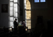 Worshippers wearing face masks to prevent the spread of the coronavirus, pray during the Easter vigil Mass at the St. Trinity Church in a small town Tverecius, some 135km (83.1 miles) northeast of the capital Vilnius, Lithuania, on Saturday, April 3, 2021. (AP Photo/Mindaugas Kulbis)