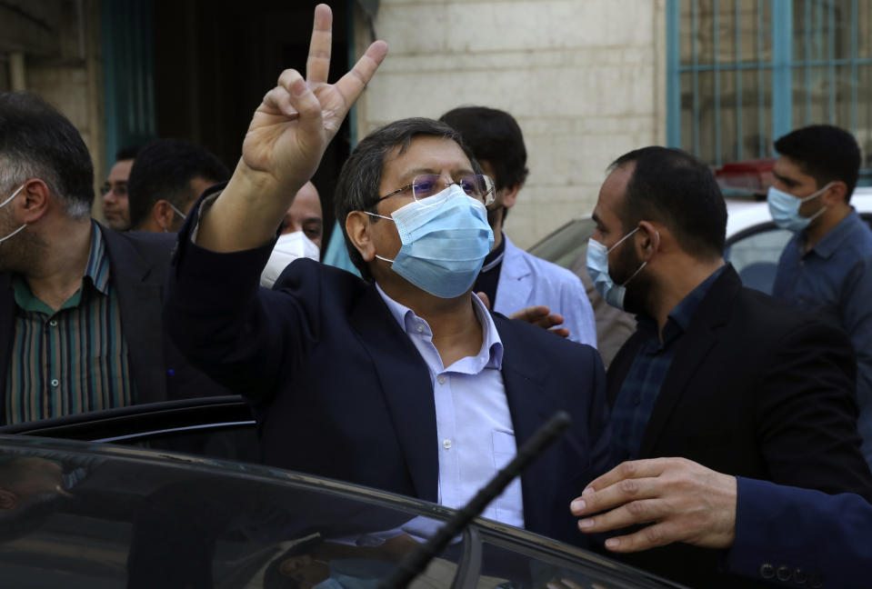 Candidate for the presidential election Abdolnasser Hemmati, former Central Bank chief, flashes the victory sign after voting at a polling station Tehran, Iran, Friday, June 18, 2021. Iran began voting Friday in a presidential election tipped in the favor of a hard-line protege of Supreme Leader Ayatollah Ali Khamenei, fueling public apathy and sparking calls for a boycott in the Islamic Republic. (AP Photo/Vahid Salemi)