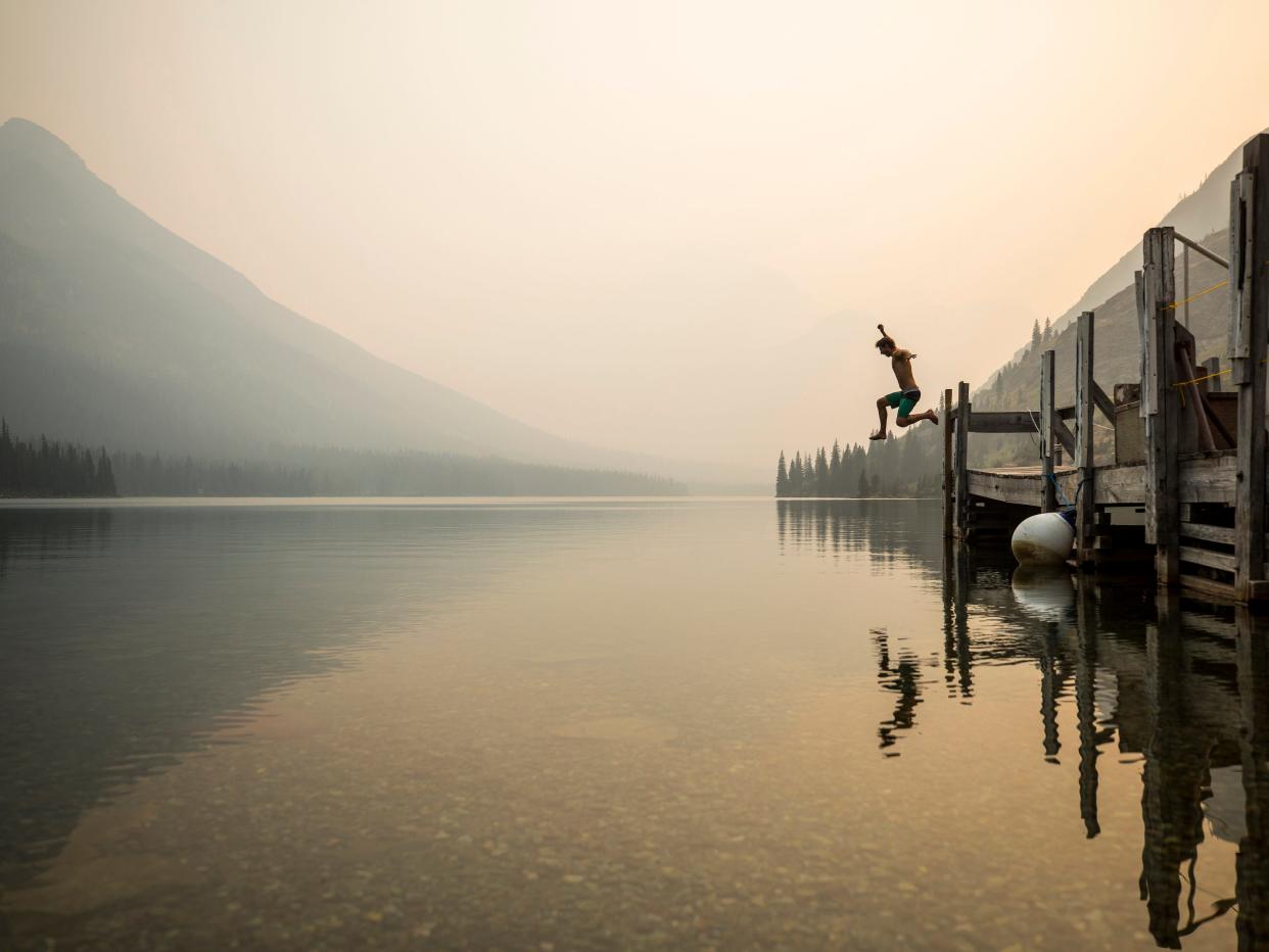 A man jumps into a foggy lake