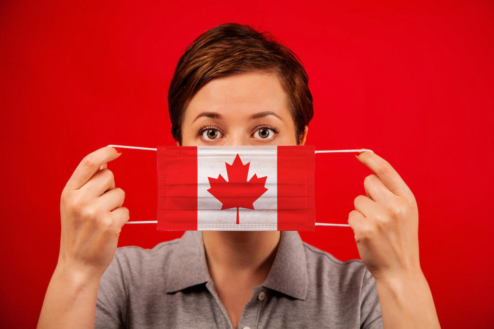 Coronavirus COVID-19 in Canada. Woman in medical protective mask with the image of the flag of Canada. The concept of preventing the spread of the epidemic and treating coronavirus.