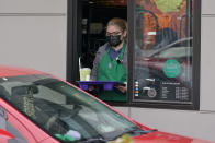 A barista serves up a drink in the drive through lane at a Starbucks Coffee store in south Seattle, Tuesday, Oct. 27, 2020. Starbucks saw faster-than-expected recovery in the U.S. and China in its fiscal fourth quarter, giving it confidence as it heads into the holiday season. (AP Photo/Ted S. Warren)