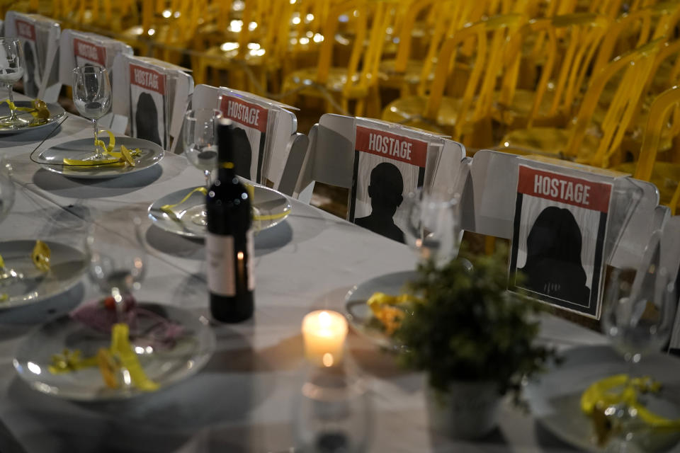 A table is set for hostages being held in the Gaza Strip, in a show of solidarity, in Tel Aviv, Israel Saturday, Nov. 25, 2023. Egyptian officials said Hamas was preparing to release 14 Israeli hostages Saturday for 42 Palestinian prisoners held by Israel. (AP Photo/ Leo Correa)