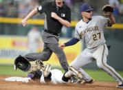 Milwaukee Brewers shortstop Willy Adames, right, looks for the throw as Colorado Rockies' Raimel Tapia, bottom left, slides safely into second base with an RBI-double in the sixth inning of a baseball game Thursday, June 17, 2021, in Denver. (AP Photo/David Zalubowski)