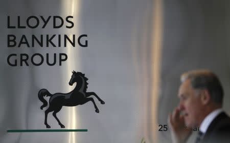 FILE PHOTO: A pedestrian passes the head office of the Lloyds Banking Group in central London August 5, 2009. REUTERS/Stefan Wermuth