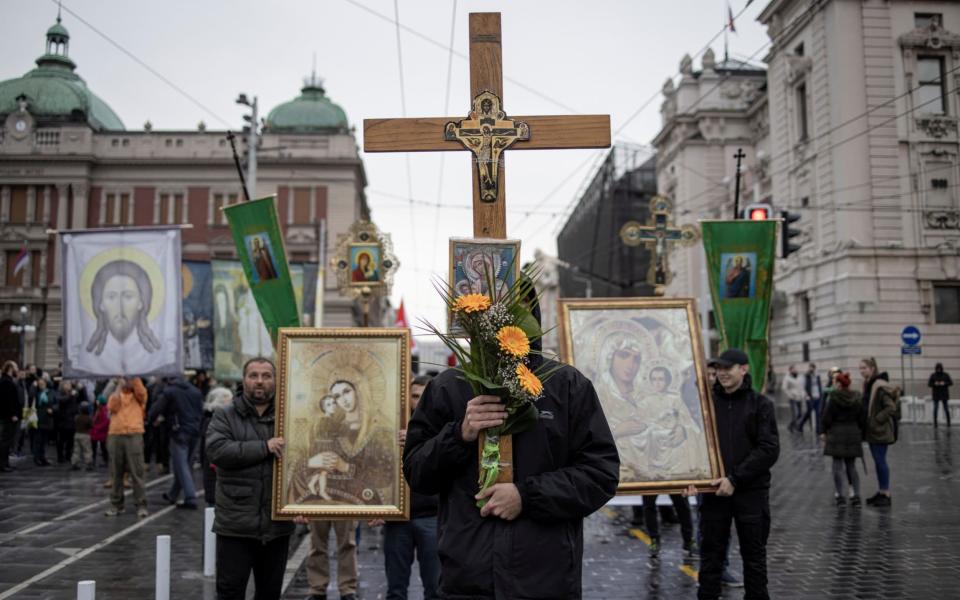 People carry Orthodox icons as they take part in a protest against coronavirus vaccination and restrictions in Belgrade - Reuters