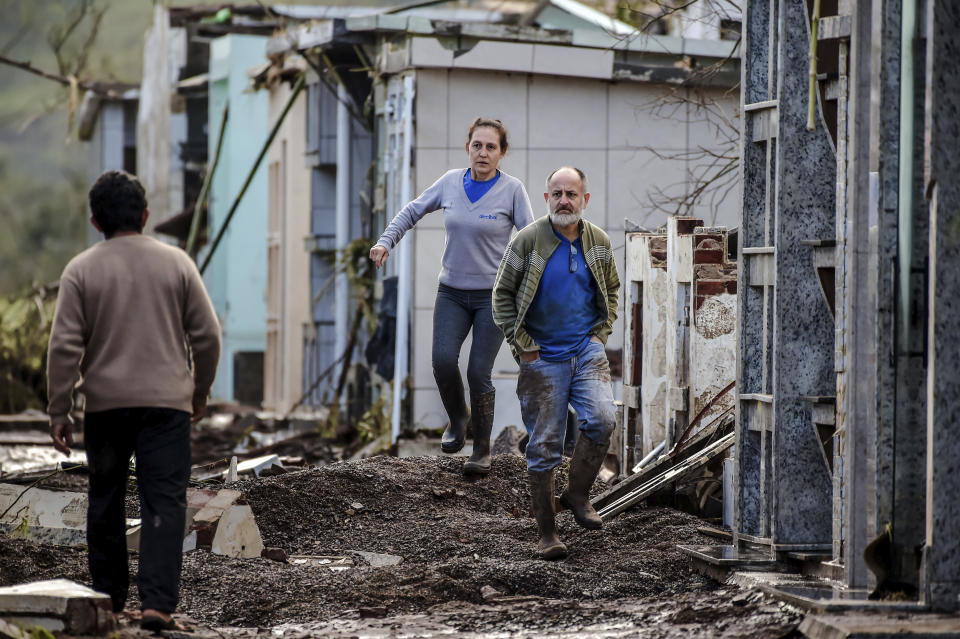 Residents assess the damage from a deadly cyclone in Mucum, Rio Grande do Sul state, Brazil, Wednesday, Sept. 6, 2023. An extratropical cyclone in southern Brazil caused floods in several cities. (AP Photo/Wesley Santos)