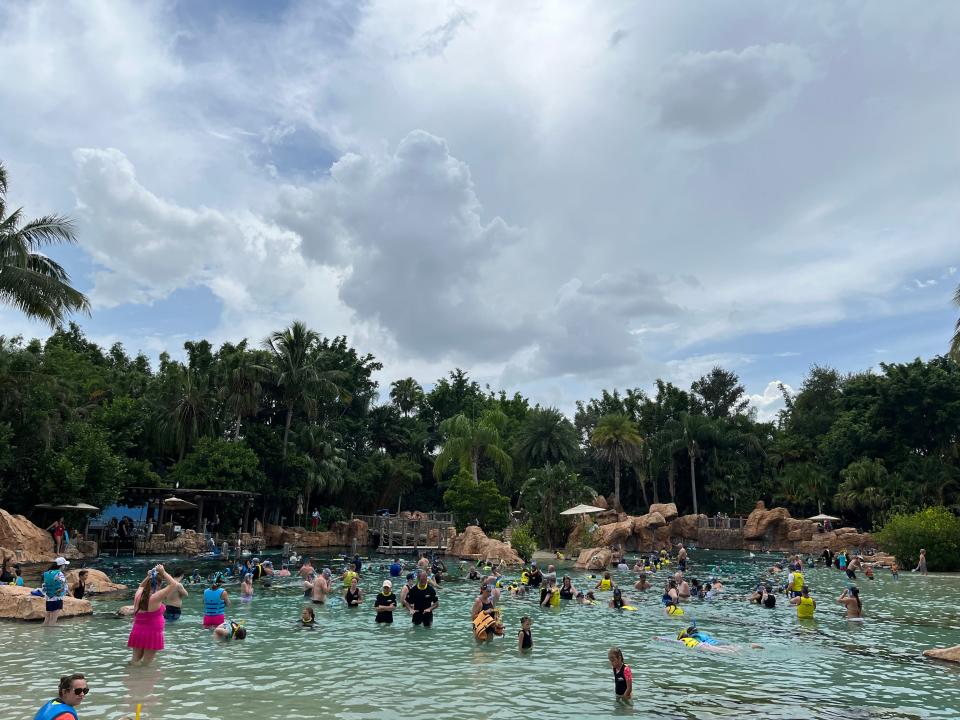 people swimming and snorkeling in the grand reef at discovery cove in orlando