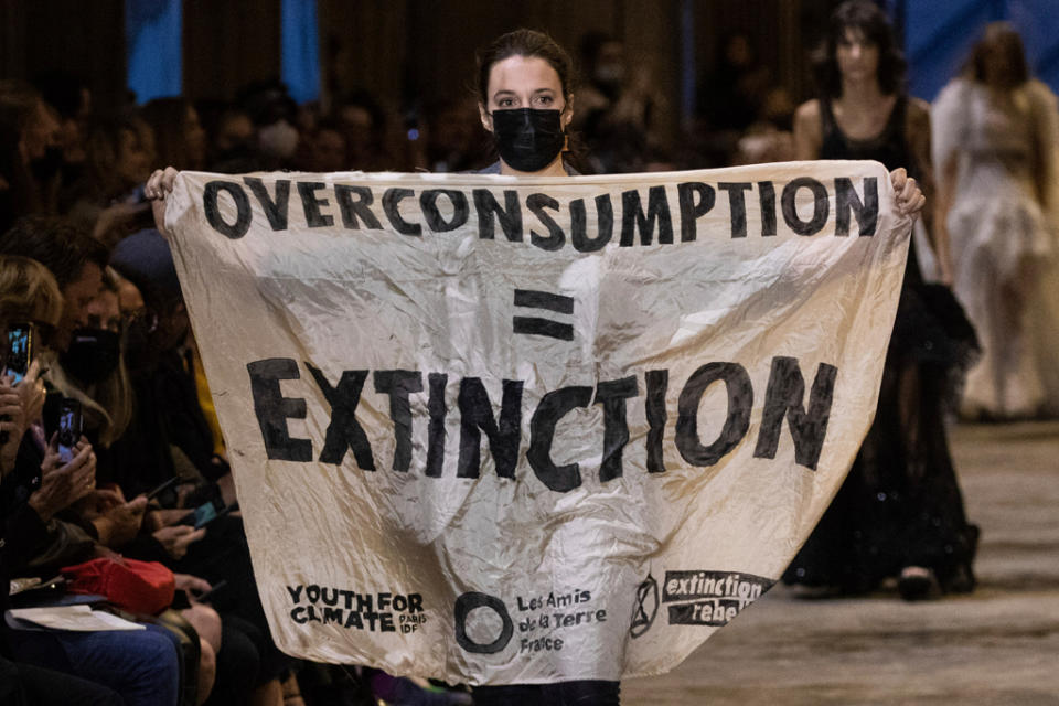 A protestor disrupts the Louis Vuitton Spring/Summer 2022 runway show during Paris Fashion Week. - Credit: AP