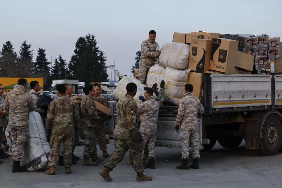 Troops load aid onto a vehicle as U.S. Secretary of State Antony Blinken visits Incirlik Air Base near Adana, Turkey, Sunday, Feb. 19, 2023. (Clodagh Kilcoyne/Pool Photo via AP)