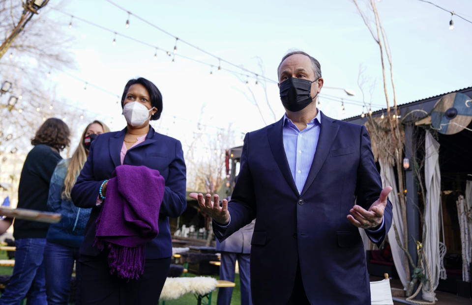 Doug Emhoff, husband of Vice President Kamala Harris, talks with members of the press as he and Washington Mayor Muriel Bowser, left, tour "Hook Hall Helps" a COVID-19 relief effort that organizes and distributes prepared meals and care kits to local hospitality workers whose jobs have been impacted by pandemic-related shutdowns and restrictions, during a visit to the organization in Washington, on Monday, March 8, 2021. (Erin Scott/Pool via AP)